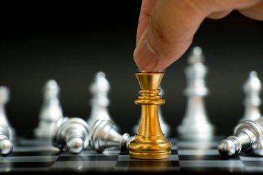 Siyah arka planda (konsept iş, liderlik zafer için satranç oyununda işadamı tutun altın Kral gümüş piyon ile uzan)