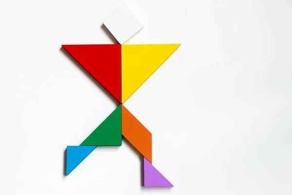 Color wood tangram puzzle on human walking shape on white background