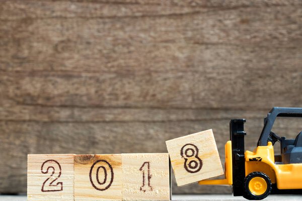 Игрушечный пластиковый вилочный захват блока сочинять и выполнять формулировки 2018 года на деревянном фоне
