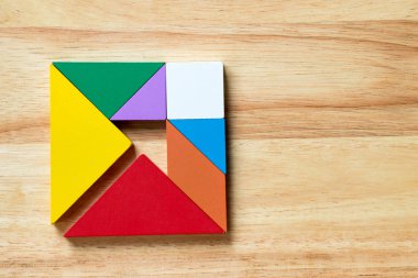 Renk tangram bulmacanın ahşap arka plan şekli içinde oklu meydanında