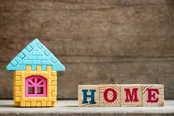Modelo de rompecabezas en forma de hogar con bloque en la redacción del hogar sobre fondo de madera —  Fotos de Stock
