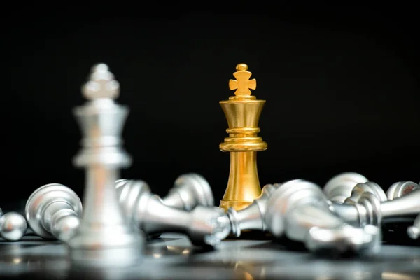 Raja emas dalam permainan catur menghadapi tim perak lain dengan latar belakang hitam (Konsep untuk strategi perusahaan, kemenangan bisnis atau keputusan) — Stok Foto