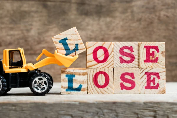 Gelbe Spielzeug Planierraupe halten Buchstabe Block l zu vervollständigen Wort verlieren auf Holz Hintergrund — Stockfoto