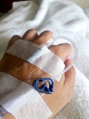 Beyaz kumaş arka plan üzerinde normal salin infüzyon tüp ile hasta el