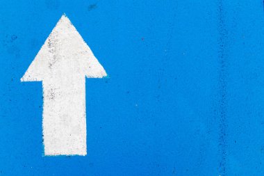 İleri yönde ok simgesi mavi beton yol arka plan üzerinde beyaz resim
