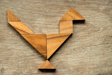 Ahşap tangram bulmacanın horoz veya horoz şekli arka planda