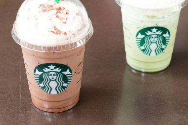 Ayutthaya, Tayland - 26 Aralık 2017 - Starbucks soğuk çikolata meşrubatının ve süt yeşil çay ile plastik kap içinde krem kırbaç. Starbucks büyük kahve Zincir mağaza olduğunu.
