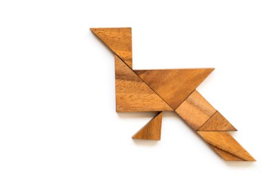 Beyaz zemin üzerine tavuskuşu şeklinde ahşap tangram bulmacanın