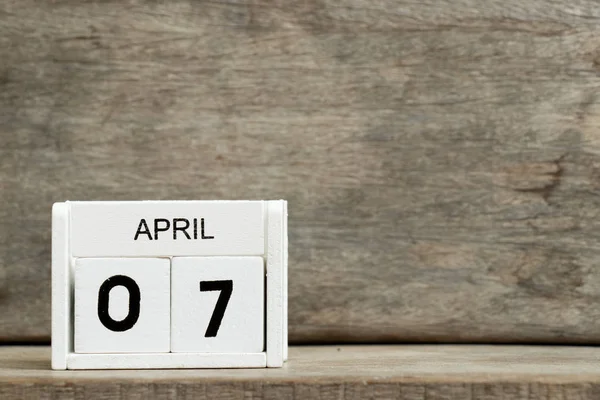 Weißer Blockkalender mit Datum 7 und Monat April auf Holzhintergrund — Stockfoto