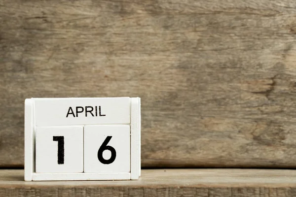 Calendario bloque blanco fecha actual 16 y mes abril sobre fondo de madera — Foto de Stock