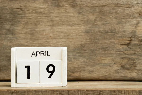 Calendario bloque blanco fecha actual 19 y mes abril sobre fondo de madera — Foto de Stock