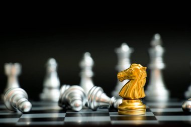 Siyah arka plan (konsept şirket stratejisi, iş zafer veya karar için başka bir gümüş takım ile satranç oyun yüzüne altın at)