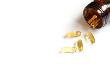 Sarı yumuşak, jelatin beyaz arka plan üzerinde kehribar şişe ile kapsül ve metin eklemek için kopya alana sahip