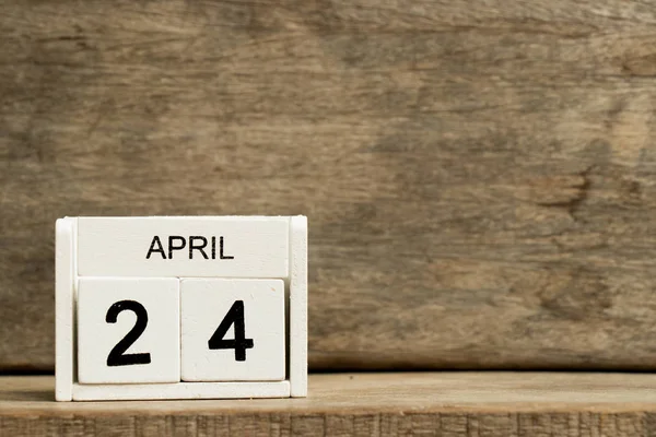 Weißer Blockkalender präsentieren Datum 24 und Monat April auf Holzhintergrund — Stockfoto