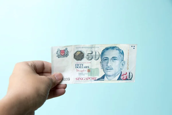 Hombre Negocios Sostiene Billete Dólares Singapur Sobre Fondo Hormigón Azul —  Fotos de Stock