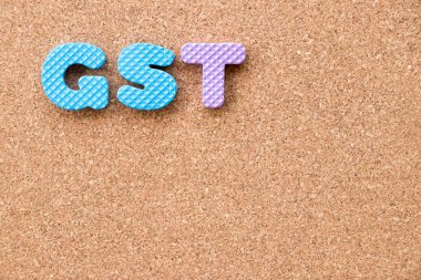 Renk oyuncak köpük alfabesi ile mantar pano arka plan üzerinde kelime Gst (kısaltma mal ve hizmet vergisi)