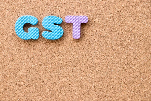 Renk oyuncak köpük alfabesi ile mantar pano arka plan üzerinde kelime Gst (kısaltma mal ve hizmet vergisi)