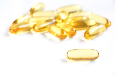 Beyaz arka plan (tıp, ilaç, beslenme ek kavramı üzerinde sarı renkli yumuşak jelatin kapsül)