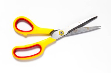 Beyaz arka planda sarı ve kırmızı plastik tutucu ile metal makas