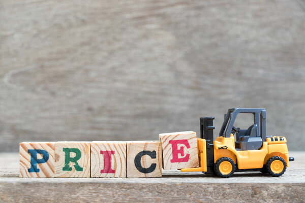 Игрушечная подложка удерживает букву Е для дополнения цены слова на деревянном фоне
