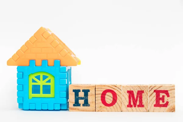 Brinquedo quebra-cabeça conectar como forma de casa e bloco de madeira em casa palavra sobre fundo branco — Fotografia de Stock