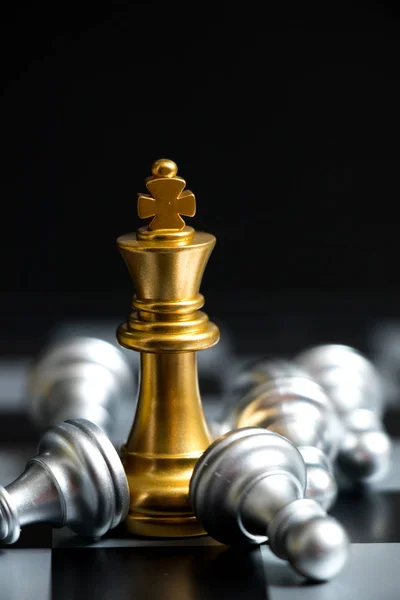 Gold King in chess game face with the another silver team on black background (Concept for company strategy, business victory or decision) — Stock Photo, Image