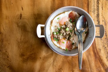 Ev yapımı kızarmış yumurta, domuz eti ve ahşap Resepsiyon arka plan üzerinde paslanmaz saç Tay sosis