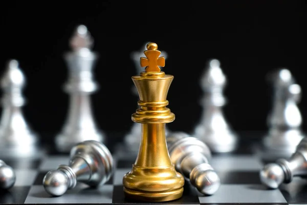 Raja emas dalam permainan catur menghadapi tim perak lain dengan latar belakang hitam (Konsep untuk strategi perusahaan, kemenangan bisnis atau keputusan) — Stok Foto