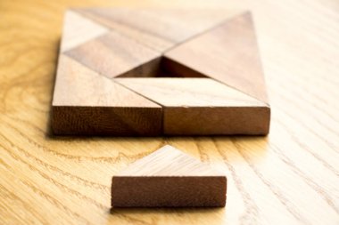 Tangram bulmacanın komple ahşap arka plan üzerinde bekleyin kare şeklinde