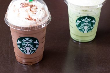 Ayutthaya, Tayland - 26 Aralık 2017 - Starbucks soğuk çikolata meşrubatının ve süt yeşil çay ile plastik kap içinde krem kırbaç. Starbucks büyük kahve Zincir mağaza olduğunu.