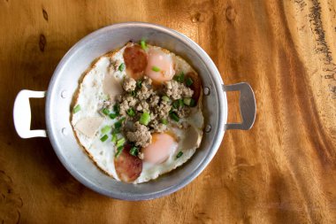 Ev yapımı kızarmış yumurta, domuz eti ve ahşap Resepsiyon arka plan üzerinde paslanmaz saç Tay sosis