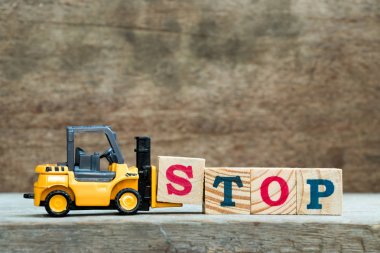 Sarı oyuncak forklift tam word durağına ahşap zemin üzerine mektup blok S tutun