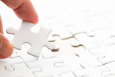 Arka plan beyaz düz jigsaw maç veya yerine getirmek için eksik parçası tutan el ile kapalı