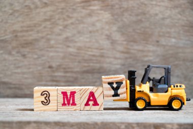 Oyuncak forklift tutun blok ahşap arka plan (ay Mayıs için takvim tarihini konsepti üzerinde tam word 3 Y olabilir)