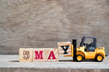 Oyuncak forklift tutun blok ahşap arka plan (ay Mayıs için takvim tarihini konsepti üzerinde tam word 5 Y olabilir)