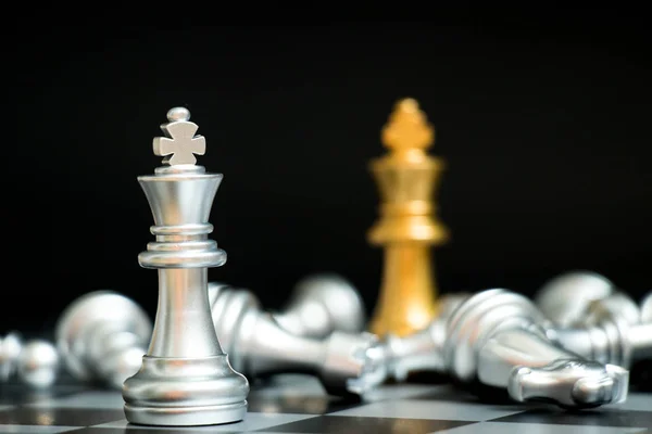 Gold king in chess game face with the another silver team on black background (Concept for company strategy, business victory or decision) — Stock Photo, Image