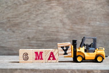 Oyuncak forklift tutun blok ahşap arka plan (ay Mayıs için takvim tarihini konsepti üzerinde tam word 6 Y olabilir)