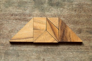 Ahşap arka plan üzerinde Trapez şeklinde bulmaca Tangram