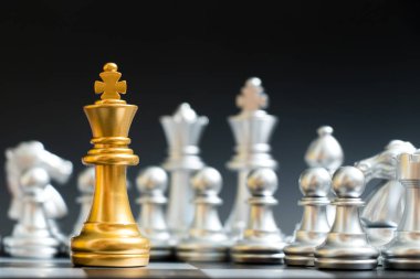 Altın Kral satranç taşını yüz siyah arka plan üzerine başka bir gümüş takım