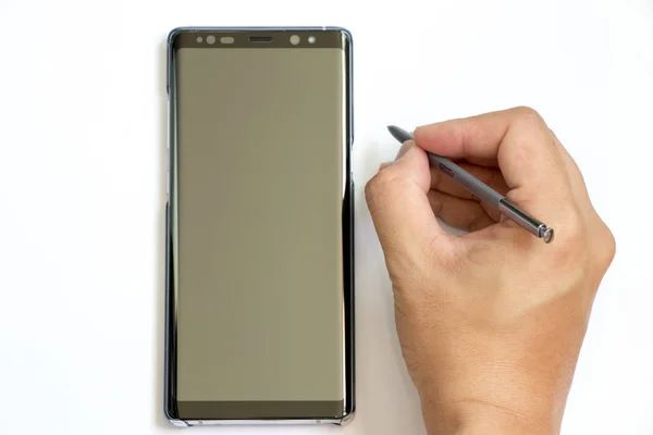 BANGKOK, THAILAND - 23 decembrie 2017: Omul de afaceri deține stylus pentru a scrie la Samsung Galaxy Note 8 pe fundal alb. Este smartphone-ul emblematic cu Android OS . — Fotografie, imagine de stoc