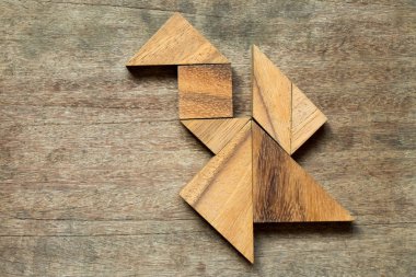 Uçan Kuş veya ahşap arka plan üzerinde dragon şekil bulmaca Tangram