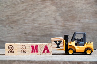 Oyuncak forklift tutun blok ahşap arka plan (ay Mayıs için takvim tarihini konsepti üzerinde tam word 22 Y olabilir)