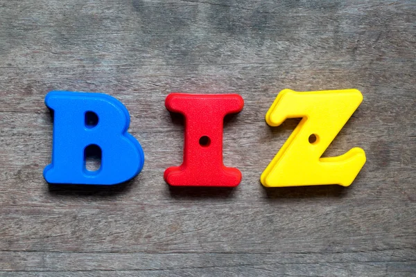 Χρώμα αλφάβητο στην λέξη biz (σύντμηση της επιχείρησης) σε ξύλο φόντο — Φωτογραφία Αρχείου