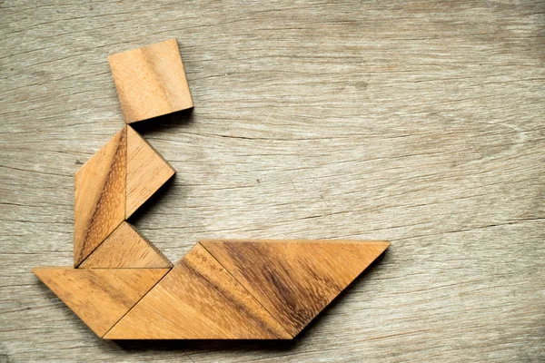 Tangram puzzle člověka plachty lodí obrazec na dřevěné pozadí — Stock fotografie