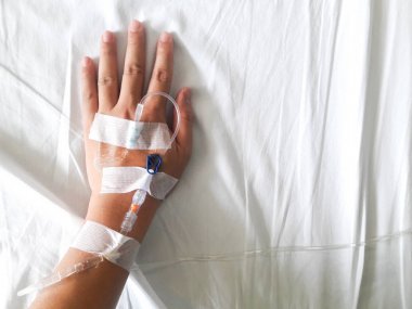 Beyaz kumaş arka plan üzerinde normal salin infüzyon tüp ile hasta el
