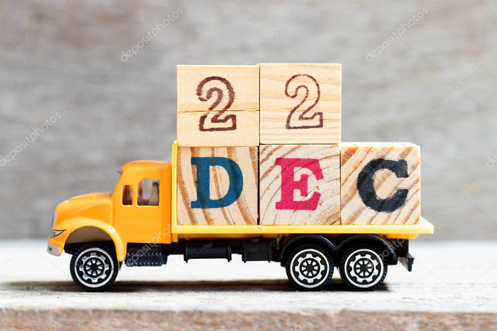 Truck hold letter block in word 22dec on wood background (Concept for date 22 month December)