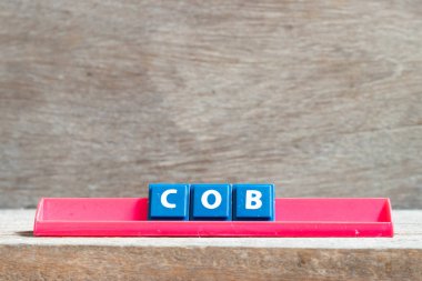Ahşap arkaplanda kırmızı raftaki döşeme harfi Cob (işin kısaltması)
