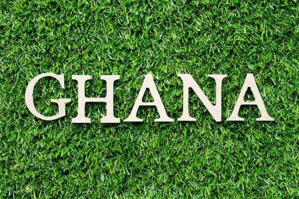 Alfabeto de madeira letra em palavra Gana no fundo grama verde — Fotografia de Stock
