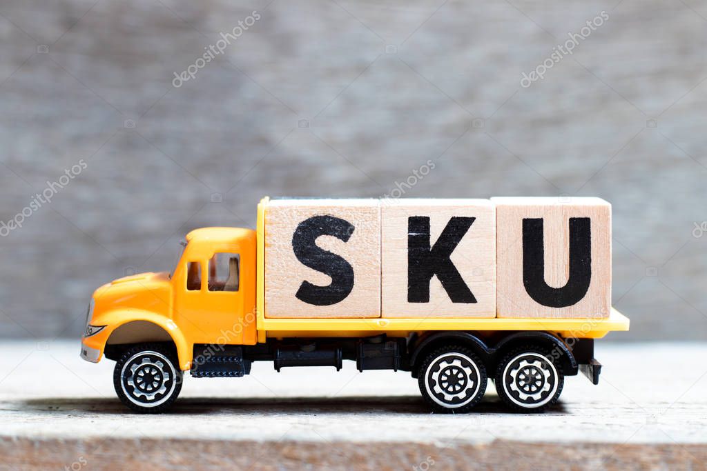 Truck hold letter block in word SKU (abbreviation of stock keeping unit) on wood background