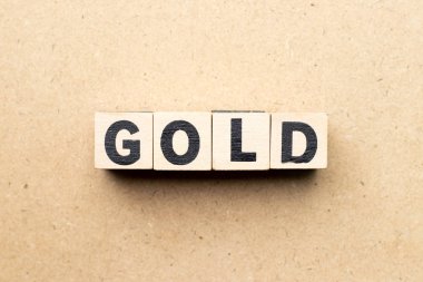 Letter block in word gold on wood background